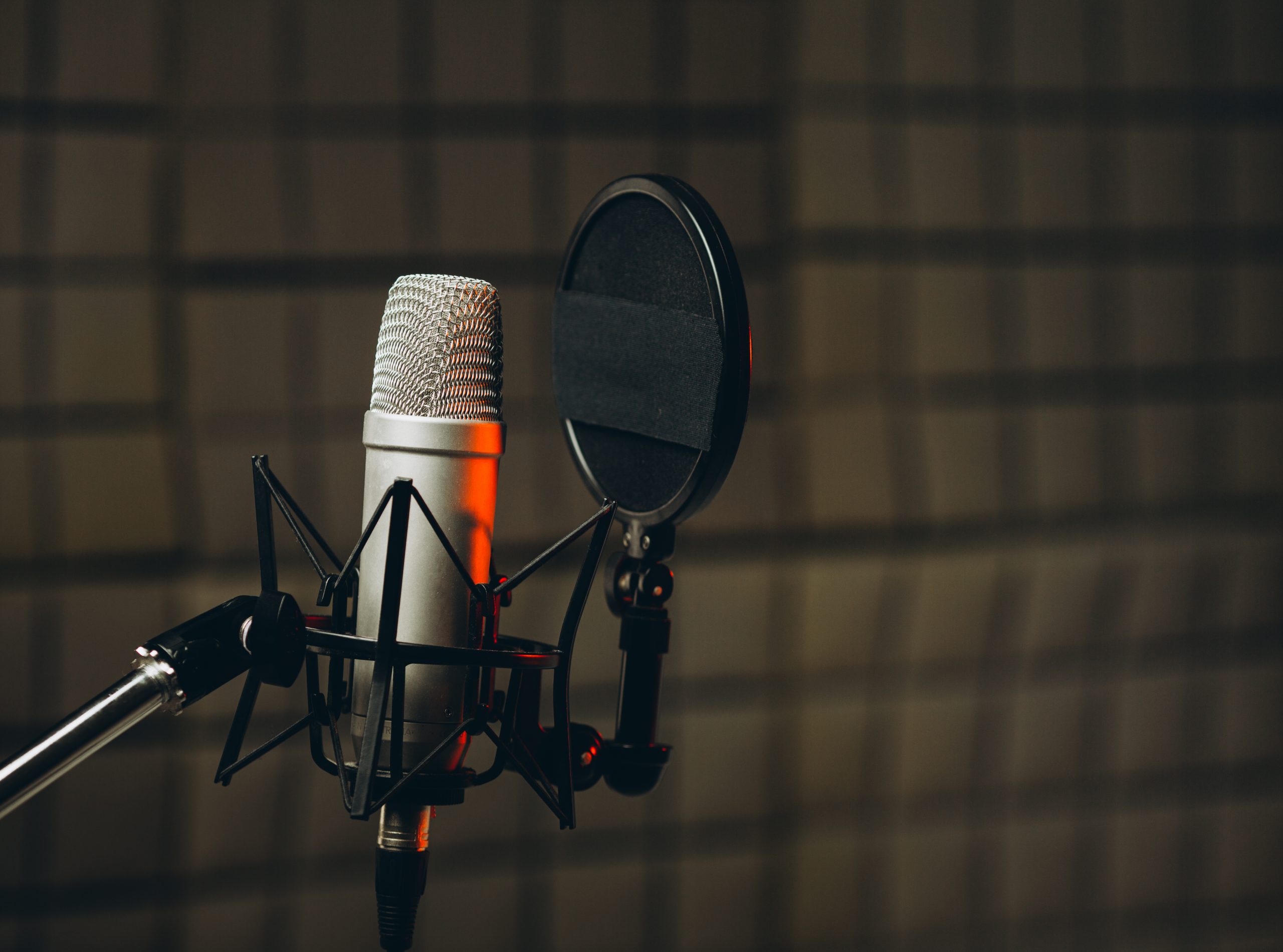 Pan shot of a professional microphone for dubbing and voice over in the sound recording studio. Close up, podcasting concept